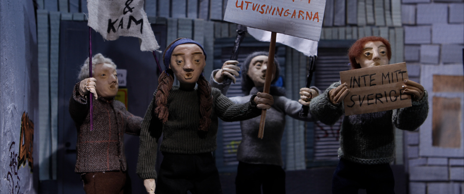 Flera dockor i demonstration, vi kan läsa "Inte mitt Sverige" på ett av plakaten.